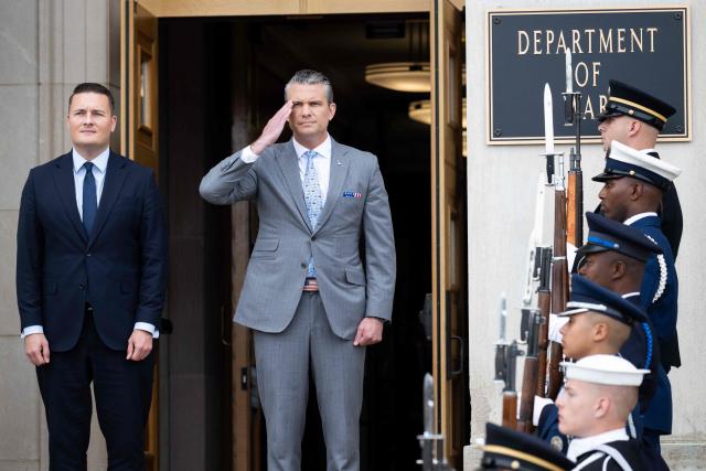 US Secretary of Defense Pete Hegseth salutes during a welcoming ceremony ahead of a meeting with UK Defense Secretary Wes Streeting (L) at the Pentagon in Washington, DC on October 15, 2026. (Photo by SAUL LOEB / AFP)