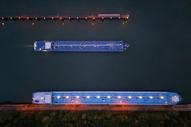 An aerial view shows vessels near the fuel depot of Aral at the Ruhr Oel petroleum refineries of BP Gelsenkirchen GmbH in Gelsenkirchen, western Germany on October 15, 2026. Ruhr Oel Gelsenkirchen refinery is one of the key production sites for fuels such as kerosene and diesel in Germany. (Photo by Ina FASSBENDER / AFP)
