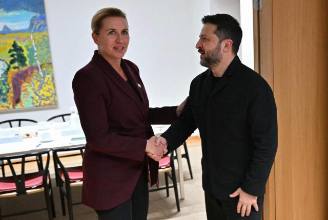 Ukraine's President Volodymyr Zelensky (R) shakes hands with Denmarks Prime Minister Mette Frederiksen (L) ahead of their bilateral meeting on the sidelines of an EU summit in Brussels on October 15, 2026. EU leaders head on October 15, 2026 for their biggest clash yet over the bloc's next long-term budget, as they race to lock in a deal before next year's French presidential election as Zelensky holds a string of bilateral talks with European leaders before joining an EU summit tomorrow. (Photo by NICOLAS TUCAT / POOL / AFP)