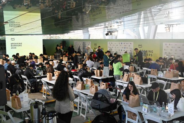 Students take part in the first Hackathon held at the University of Chile in Santiago on October 15, 2026, an event in which participants collaborate in teams to develop technology-based solutions, software applications and innovative projects within a limited period of time. Amazon Web Services (AWS) held its global Breaking Barriers hackathon in Latin America for the first time, with around 200 participants gathering at the University of Chile. Over three days, teams developed generative AI solutions to address real-world challenges in healthcare, education, digital government and sustainability. (Photo by RODRIGO ARANGUA / AFP)