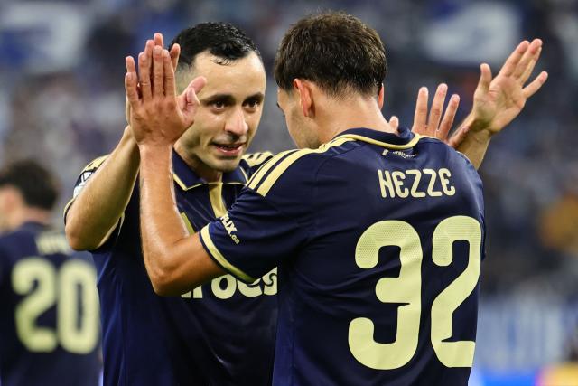 Olympiacos' midfielder #32 Santiago Hezze (R) celebrates with Olympiacos' defender #2 Manolis Saliakas (L) after scoring Olympiacos' first goal during the UEFA Europa League, league phase matchday 2, football match between Olympique de Marseille and Olympiacos at the Stade Velodrome in Marseille, on October 15, 2026. (Photo by CLEMENT MAHOUDEAU / AFP)