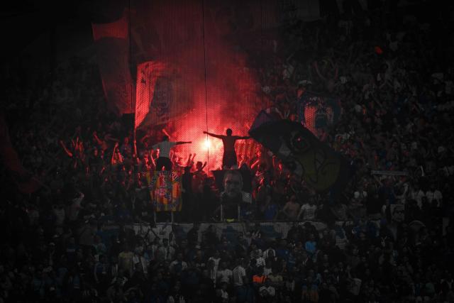 Marseille's supporters light flares as they cheer their team on from the stands during the UEFA Europa League, league phase matchday 2, football match between Olympique de Marseille and Olympiacos at the Stade Velodrome in Marseille, on October 15, 2026. (Photo by Miguel MEDINA / AFP)