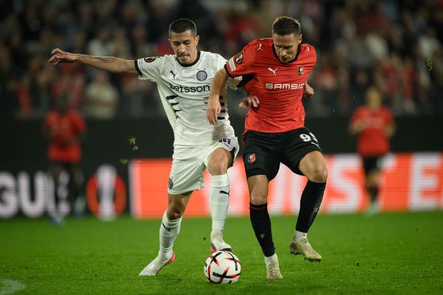OFI Crete's forward #10 Aitor Cantalapiedra (L) fights for the ball with Rennes' Polish defender #95 Przemyslaw Frankowski (R) during the UEFA Europa League, league phase matchday 2, football match between Stade Rennais and OFI Crete at the Roazhon Park in Rennes, western France on October 15, 2026. (Photo by Loic VENANCE / AFP)