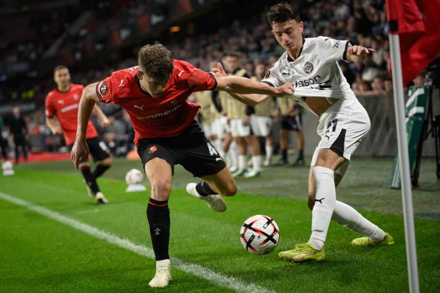 OFI Crete's midfielder #21 Ioannis Apostolakis (R) fights for the ball with Rennes' English defender #04 Charlie Cresswell (L) during the UEFA Europa League, league phase matchday 2, football match between Stade Rennais and OFI Crete at the Roazhon Park in Rennes, western France on October 15, 2026. (Photo by Loic VENANCE / AFP)