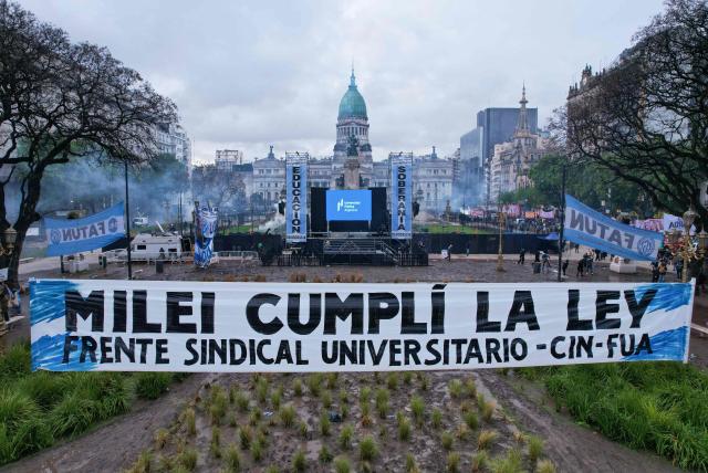 This view shows a banner reading "Milei, comply with the law" during a demonstration demanding that the government of Argentine President Javier Milei comply with a law updating funding for public universities, in Buenos Aires, on October 15, 2026. (Photo by Emiliano LASALVIA / AFP)