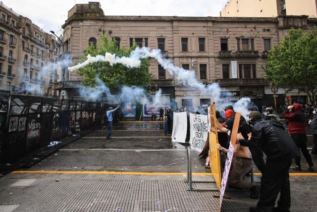 people throw tear gas during a demonstration demanding that the government of Argentine President Javier Milei comply with a law updating funding for public universities, in Buenos Aires, on October 15, 2026. (Photo by Emiliano Lasalvia / AFP)