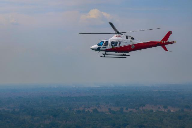 An IBAMA helicopter is seen flying over an area affected by fires in the Amazon rainforest in Autazes, in the state of Amazonas, northern Brazil on October 15, 2026. (Photo by MICHAEL DANTAS / AFP)