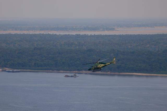 IBAMA helicopters are seen flying over the Rio Negro, near Manaus, in the state of Amazonas, northern Brazil, on October 15, 2026. (Photo by MICHAEL DANTAS / AFP)