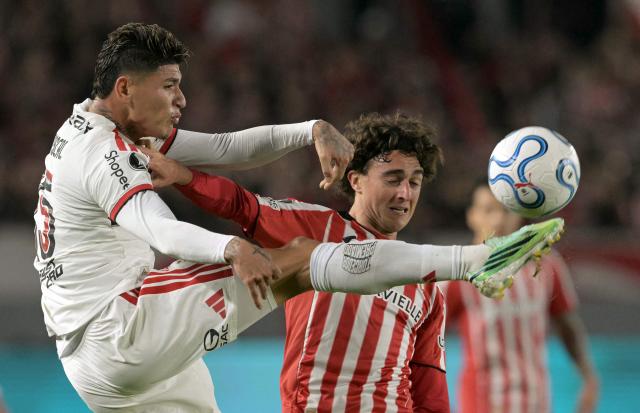 Flamengo's Colombian midfielder #15 Jorge Carrascal and Estudiantes' defender #13 Gaston Benedetti ight for the ball during the Copa Libertadores semifinal first leg football match between Argentina's Estudiantes de La Plata and Brazil's Flamengo at the UNO Jorge Luis Hirschi stadium in La Plata, Buenos Aires province, on October 15, 2026. (Photo by JUAN MABROMATA / AFP)