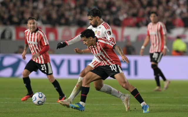 Flamengo's midfielder #11 Lucas Paqueta and Estudiantes' Uruguayan forward #10 Tiago Palacios fight for the ball during the Copa Libertadores semifinal first leg football match between Argentina's Estudiantes de La Plata and Brazil's Flamengo at the UNO Jorge Luis Hirschi stadium in La Plata, Buenos Aires province, on October 15, 2026. (Photo by JUAN MABROMATA / AFP)