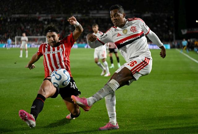 Estudiantes' defender #40 Eros Mancuso and Flamengo's defender #26 Alex Sandro fight for the ball during the Copa Libertadores semifinal first leg football match between Argentina's Estudiantes de La Plata and Brazil's Flamengo at the UNO Jorge Luis Hirschi stadium in La Plata, Buenos Aires province, on October 15, 2026. (Photo by Luis ROBAYO / AFP)