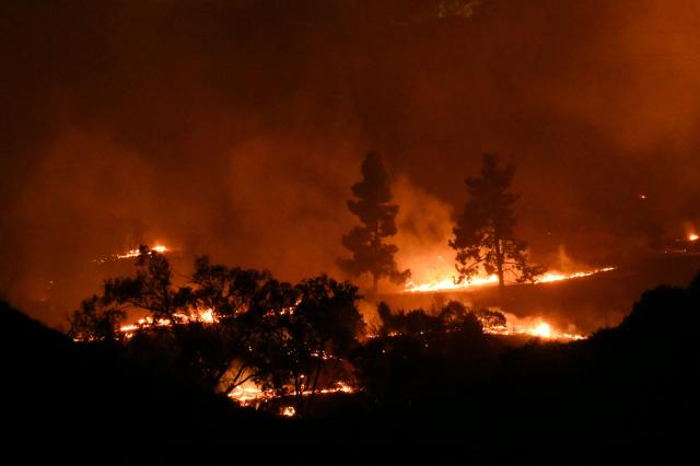 The Bryson Fire burns in Malibu, California on October 15, 2026. The brush fire in the mountains west of Los Angeles prompted evacuation warnings from officials, as powerful Santa Ana winds risked spreading the blaze rapidly. (Photo by Patrick T. Fallon / AFP)