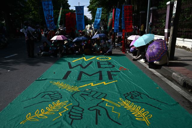 A banner is pictured as demonstrators prepare to start marching in a protest against the International Monetary Fund (IMF) and World Bank Group in Bangkok on October 16, 2026, as the IMF Annual Meetings take place in the Thai capital. (Photo by Anthony WALLACE / AFP)