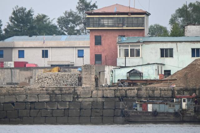 North Korean soldiers are seen on the waterfront of the Yalu River in the North Korean town of Sinuiju, viewed from the border city of Dandong, in China's northeast Liaoning province, on October 15, 2026.  (Photo by Michael ZHANG / AFP)