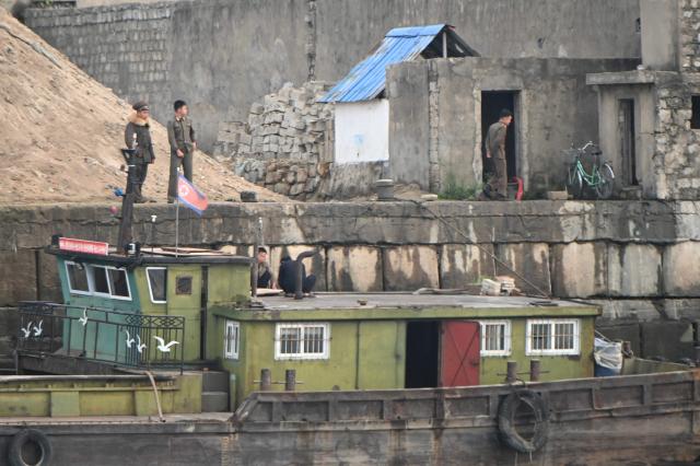 North Korean soldiers are seen on the waterfront of the Yalu River in the North Korean town of Sinuiju, viewed from the border city of Dandong, in China's northeast Liaoning province, on October 15, 2026.  (Photo by Michael ZHANG / AFP)