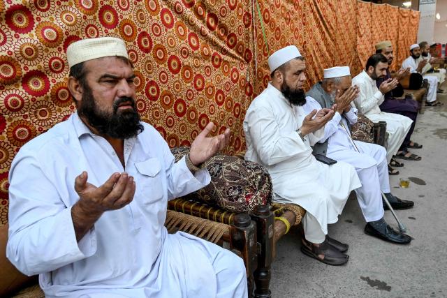 People pray for students killed after a roof collapsed at a school, in Peshawar on October 16, 2026. The roof of a school collapsed in Pakistan's northwestern city of Peshawar on October 16, killing 32 students mostly younger than 14, and a teacher, officials said, blaming the accident on dilapidated infrastructure. (Photo by Abdul MAJEED / AFP)