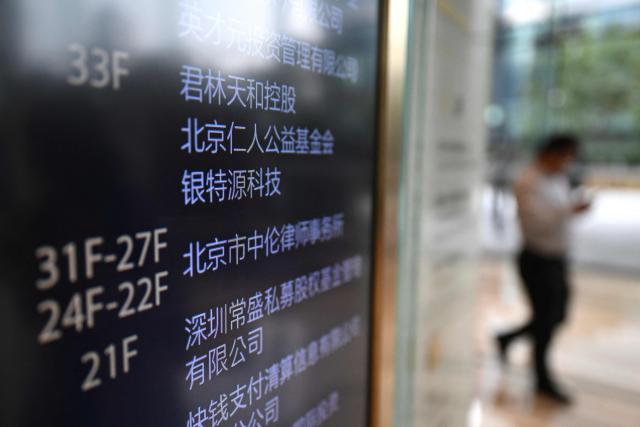 A directory showing the name of Zhong Lun Law Firm is seen in the lobby of the building where new White House Press Secretary Katie Zacharia previously worked as a lawyer in Beijing on October 16, 2026. (Photo by Pedro PARDO / AFP)