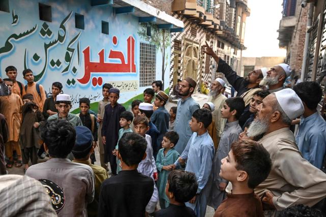 People gather outside a school a day after its roof collapsed killing several students in Peshawar on October 16, 2026. The roof of a school collapsed in Pakistan's northwestern city of Peshawar on October 16, killing 32 students mostly younger than 14, and a teacher, officials said, blaming the accident on dilapidated infrastructure. (Photo by Abdul MAJEED / AFP)