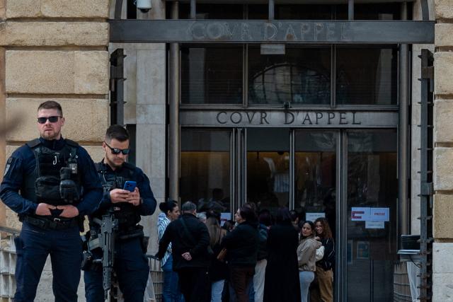 (FILES) French Republican Security Corps (CRS) police officers guard the entrance of the courthouse on the opening day of the trial of alleged members of the DZ Mafia drug trafficking organisation over a double murder committed in 2019, in Aix-en-Provence, southern France on March 23, 2026. In Marseille, gunfire has become less frequent: there have been five drug-related killings since January, 2026. This lull is attributed both to the ‘hegemony’ of the DZ Mafia and to the police and judicial crackdown on several of its key figures, who are now behind bars. (Photo by Elodie CLEMENT / AFP)