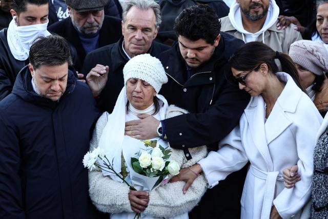(FILES) French anti-drug activist Amine Kessaci (C) and his mother Ouassila Benhamdi Kessaci (L) gather to take part in a march in tribute to Mehdi Kessaci at the roundabout where he was murdered  and to protest against drug trafficking, in Marseille, southern France on November 22, 2025. The trial of the alleged killers of the older brother of anti-drug trafficking activist Amine Kessaci and of two other young men, killed in December 2020, will take place in Aix-en-Provence from October 19 to November 6, 2026. (Photo by CLEMENT MAHOUDEAU / AFP)
