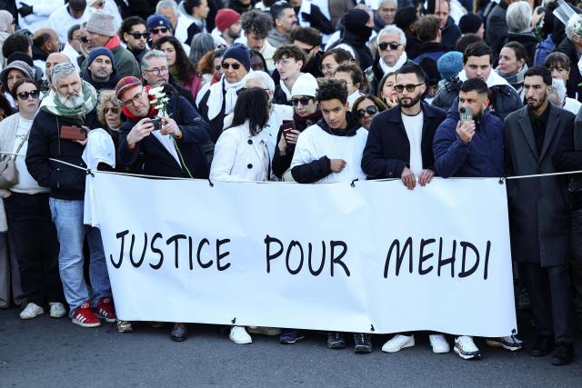 (FILES) Protesters holds a banner reading "Justice for Mehdi" as they take part in a march in tribute to Mehdi Kessaci, brother of ecologist and anti-drug activist Amine Kessaci, at the roundabout where he was murdered and to protest against drug trafficking, in Marseille, southern France on November 22, 2025. The trial of the alleged killers of the older brother of anti-drug trafficking activist Amine Kessaci and of two other young men, killed in December 2020, will take place in Aix-en-Provence from October 19 to November 6, 2026. (Photo by CLEMENT MAHOUDEAU / AFP)