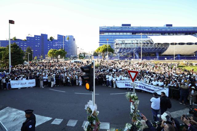 (FILES) People gather to take part in a march in tribute to Mehdi Kessaci, brother of ecologist and anti-drug activist Amine Kessaci, at the roundabout where he was murdered, and to protest against drug trafficking, in Marseille, southern France, on November 22, 2025. The trial of the alleged killers of the older brother of anti-drug trafficking activist Amine Kessaci and of two other young men, killed in December 2020, will take place in Aix-en-Provence from October 19 to November 6, 2026. (Photo by Clement MAHOUDEAU / AFP)
