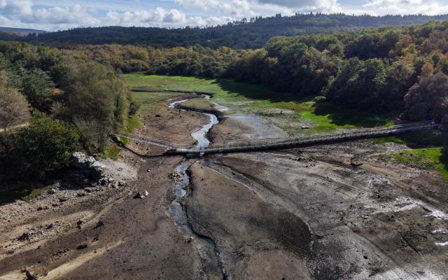 This aerial photograph shows Lake Drennec, where water levels have dropped due to drought, in Sizun, western France, on October 14, 2026. Water resources in the Brest area and across the Finistère department are under severe pressure due to a significant rainfall deficit. (Photo by Fred TANNEAU / AFP)