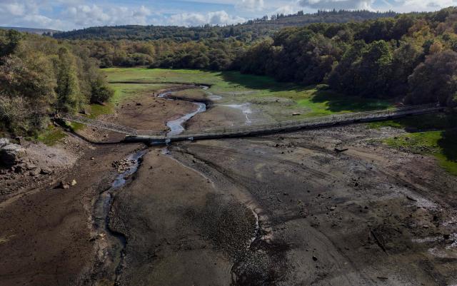 This aerial photograph shows Lake Drennec, where water levels have dropped due to drought, in Sizun, western France, on October 14, 2026. Water resources in the Brest area and across the Finistère department are under severe pressure due to a significant rainfall deficit. (Photo by Fred TANNEAU / AFP)