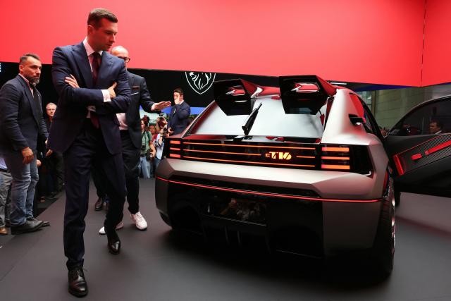 President of French far-right party Rassemblement National (RN) Jordan Bardella looks at a Peugeot E-T16 Concept electric car as he visits the Peugeot stand during the 91st edition of the international Paris Motor Show at the Porte de Versailles in Paris on October 16, 2026. (Photo by Thomas SAMSON / AFP)