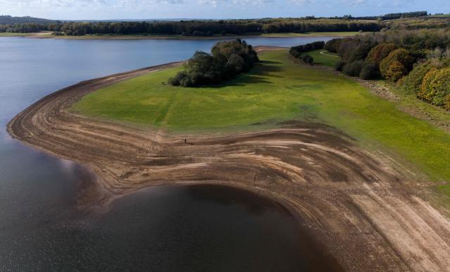 This aerial photograph shows Lake Drennec, where water levels have dropped due to drought, in Sizun, western France, on October 14, 2026. Water resources in the Brest area and across the Finistère department are under severe pressure due to a significant rainfall deficit. (Photo by Fred TANNEAU / AFP)
