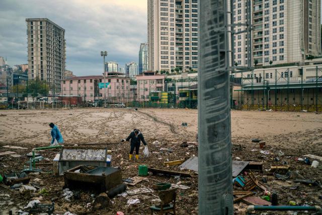 Women work to clean debris on a football pitch covered with mud one day after heavy rain caused flooding in the Ayazaga district of Istanbul on October 16, 2026. Istanbul was on October 15, 2026 battling to recover from flooding caused by what officials said was the heaviest rainfall in the city since records began more than 80 years ago, as the downpour continued. The rain began lashing Turkey's largest city in earnest on Wednesday morning and intensified throughout the day, causing chaos and flash flooding, with footage showing cars being dragged away by the fast-flowing waters. (Photo by Yasin AKGUL / AFP)