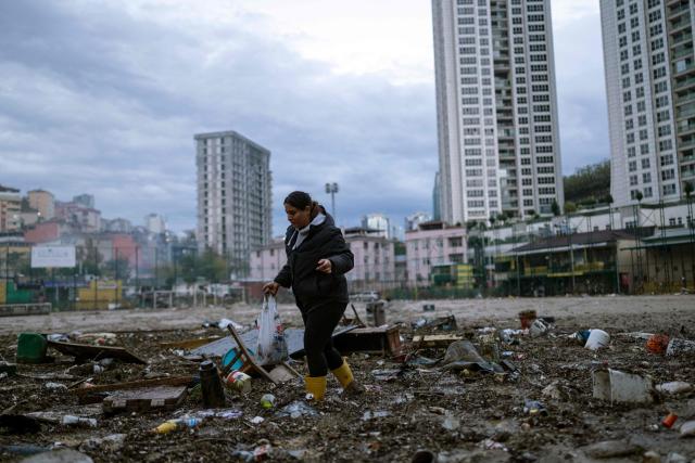 A woman works to clean debris on a football pitch covered with mud one day after heavy rain caused flooding in the Ayazaga district of Istanbul on October 16, 2026. Istanbul was on October 15, 2026 battling to recover from flooding caused by what officials said was the heaviest rainfall in the city since records began more than 80 years ago, as the downpour continued. The rain began lashing Turkey's largest city in earnest on Wednesday morning and intensified throughout the day, causing chaos and flash flooding, with footage showing cars being dragged away by the fast-flowing waters. (Photo by Yasin AKGUL / AFP)