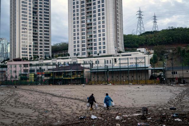 Women work to clean debris on a football pitch covered with mud one day after heavy rain caused flooding in the Ayazaga district of Istanbul on October 16, 2026. Istanbul was on October 15, 2026 battling to recover from flooding caused by what officials said was the heaviest rainfall in the city since records began more than 80 years ago, as the downpour continued. The rain began lashing Turkey's largest city in earnest on Wednesday morning and intensified throughout the day, causing chaos and flash flooding, with footage showing cars being dragged away by the fast-flowing waters. (Photo by Yasin AKGUL / AFP)