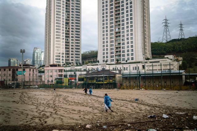 Women work to clean debris on a football pitch covered with mud one day after heavy rain caused flooding in the Ayazaga district of Istanbul on October 16, 2026. Istanbul was on October 15, 2026 battling to recover from flooding caused by what officials said was the heaviest rainfall in the city since records began more than 80 years ago, as the downpour continued. The rain began lashing Turkey's largest city in earnest on Wednesday morning and intensified throughout the day, causing chaos and flash flooding, with footage showing cars being dragged away by the fast-flowing waters. (Photo by Yasin AKGUL / AFP)