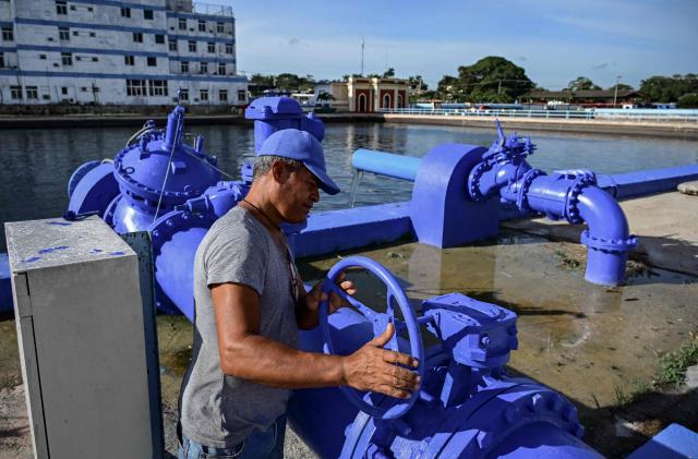 A worker operates a valve to fill a water reservoir at the Albear Aqueduct, which supplies water to several municipalities in Havana, Cuba, on October 16, 2026. (Photo by YAMIL LAGE / AFP)