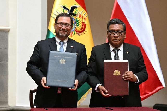 Chil'sn Foreign Minister Francisco Perez Mackenna and Bolivia's Foreign Minister Hector Huanca hold signed documents during a signing ceremony at the Palacio Quemado presidential palace in La Paz on October 16, 2026. (Photo by AIZAR RALDES / AFP)