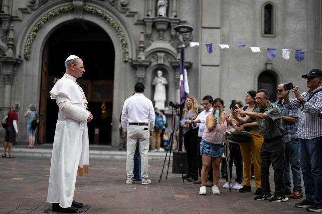 People take photographs of a hyperrealistic silicone statue of Pope Leo XIV, created by Peruvian artist Walter Huamán, in Lima, Peru, on October 16, 2026. (Photo by ERNESTO BENAVIDES / AFP)