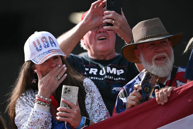 Supporters react as Marine One carrying US President Donald Trump comes in to land at Dalton Municipal Airport in Dalton, Georgia, on October 16, 2026. Trump is travelling to Georgia to attend a midterm election campaign. (Photo by Brendan SMIALOWSKI / AFP)