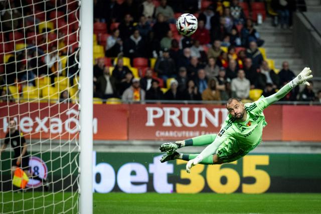 Le Mans' French goalkeeper #98 Nicolas Kocik (R) dives unsuccessfully as Toulouse score their first goal during the French L1 football match between Le Mans FC and Toulouse FC at the Stade Marie-Marvingt in Le Mans, northwestern France, on October 16, 2026. (Photo by Guillaume SALIGOT / AFP)