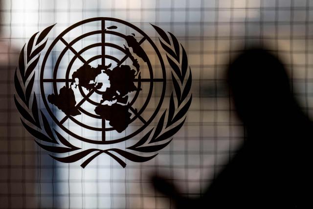 (FILES) A person walks past the UN logo at UN headquarters in New York City on February 8, 2024. All seven candidates to lead the United Nations received a vote of "discourage," effectively a veto, from a permanent UN Security Council member in the latest informal poll, a diplomat said October 16, 2026. October 16th's vote was the first time in six rounds of informal straw polling that Britain, China, France, Russia and the United States anonymously used colored straws to indicate vetoes, while the 10 elected members continued to use plain markers. (Photo by ANGELA WEISS / AFP)