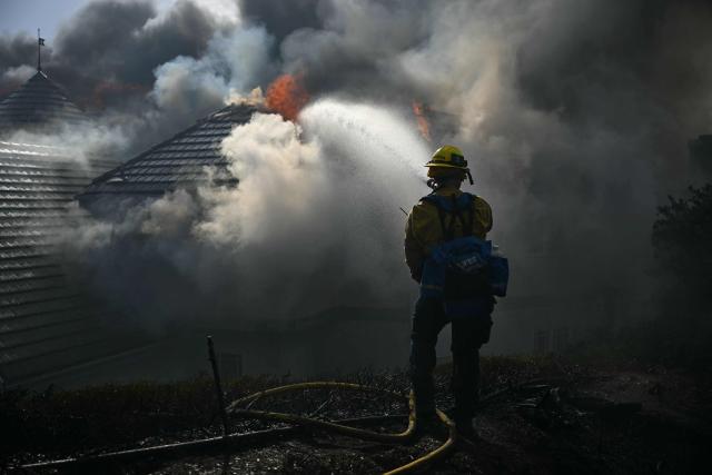 A firefighter battles the Norte Fire in San Juan Capistrano, California, on October 16, 2026. Evacuation orders have been issued for parts of Orange County. (Photo by Patrick T. Fallon / AFP)