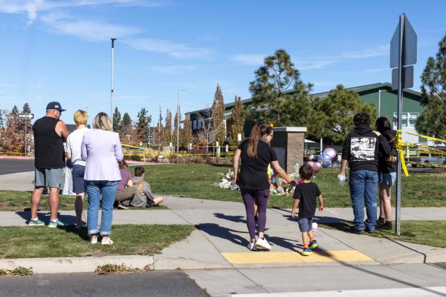 People gather outside of Silver Rail Elementary School in Bend, Oregon, on October 16, 2026. Three children and one teacher were shot dead at an elementary school on October 15 in the northwestern US state of Oregon, police said, adding that the assailant was a 16-year-old who was killed by an armed bystander. (Photo by Payton Bruni / AFP)