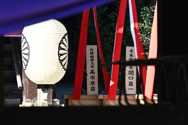 A wooden plaque (L) bearing the name of Japan’s Prime Minister Sanae Takaichi is seen beside a “masakaki” tree that she sent as an offering to the Yasukuni Shrine on the first day of the Autumn Festival in Tokyo on October 17, 2026. (Photo by Rie KIKUCHI / AFP)