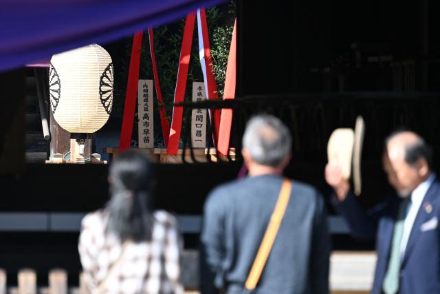 A wooden plaque (L, background) bearing the name of Japan’s Prime Minister Sanae Takaichi is seen beside a “masakaki” tree that she sent as an offering to the Yasukuni Shrine on the first day of the Autumn Festival in Tokyo on October 17, 2026. (Photo by Rie KIKUCHI / AFP)