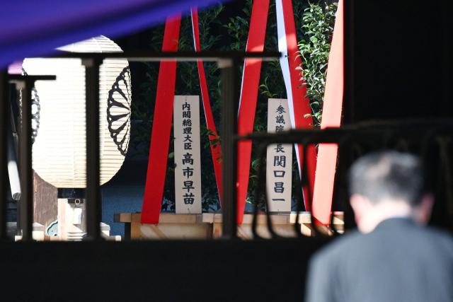 A wooden plaque (L) bearing the name of Japan’s Prime Minister Sanae Takaichi is seen beside a “masakaki” tree that she sent as an offering to the Yasukuni Shrine on the first day of the Autumn Festival in Tokyo on October 17, 2026. (Photo by Rie KIKUCHI / AFP)