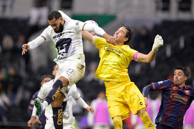 Pumas' Brazilian forward #23 Juninho Vieira and Atlante's goalkeeper #01 Oscar Francisco Jimenez fight for the ball during the Liga MX Apertura tournament football match between Atlante and Pumas at the Ciudad de los Deportes stadium in Mexico City on October 16, 2026. (Photo by Alfredo ESTRELLA / AFP)