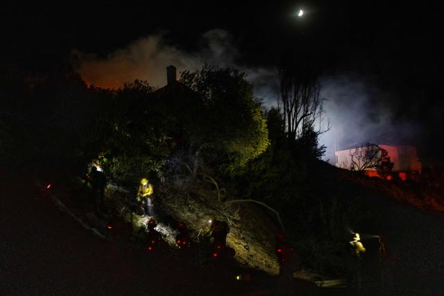 Firefighters battle the Norte Fire while it burns a house in San Juan Capistrano, California, on October 16, 2026. Wind-whipped flames scorched multi-million dollar homes south of Los Angeles on Friday as a wildfire quickly ravaged hundreds of acres. (Photo by Apu GOMES / AFP)