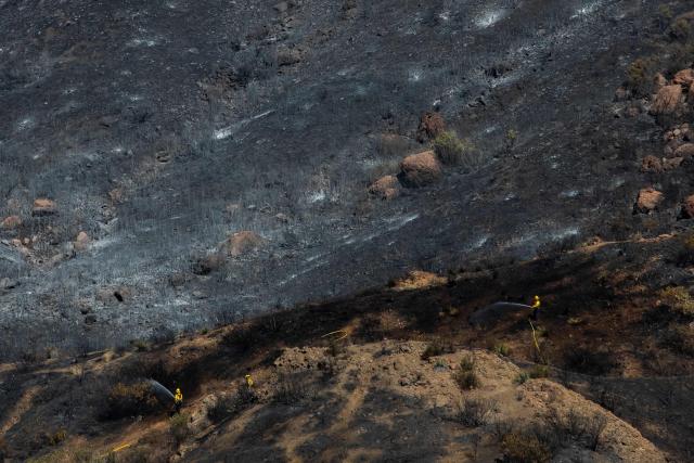 Firefighters combat hotspots at the Bryson Fire in Malibu, California on October 16, 2026. A brush fire in the mountains west of Los Angeles prompted evacuation warnings from officials on Thursday, as powerful winds risked spreading the blaze rapidly. (Photo by Apu GOMES / AFP)