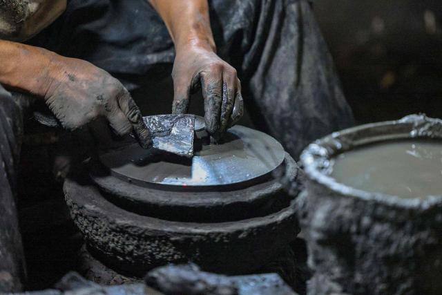 A worker shapes Yingjing black sand pottery at a sandware factory in Yingjing County, Ya'an, in southwestern China's Sichuan province, on October 16, 2026. (Photo by CN-STR / AFP) / China OUT