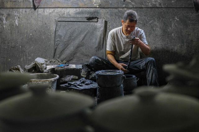 A worker shapes Yingjing black sand pottery at a sandware factory in Yingjing County, Ya'an, in southwestern China's Sichuan province, on October 16, 2026. (Photo by CN-STR / AFP) / China OUT